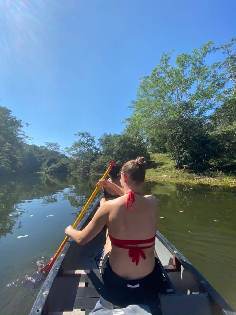Back of girl in red bathing suit canoeing macal river near san ignacio belize, chaa creek