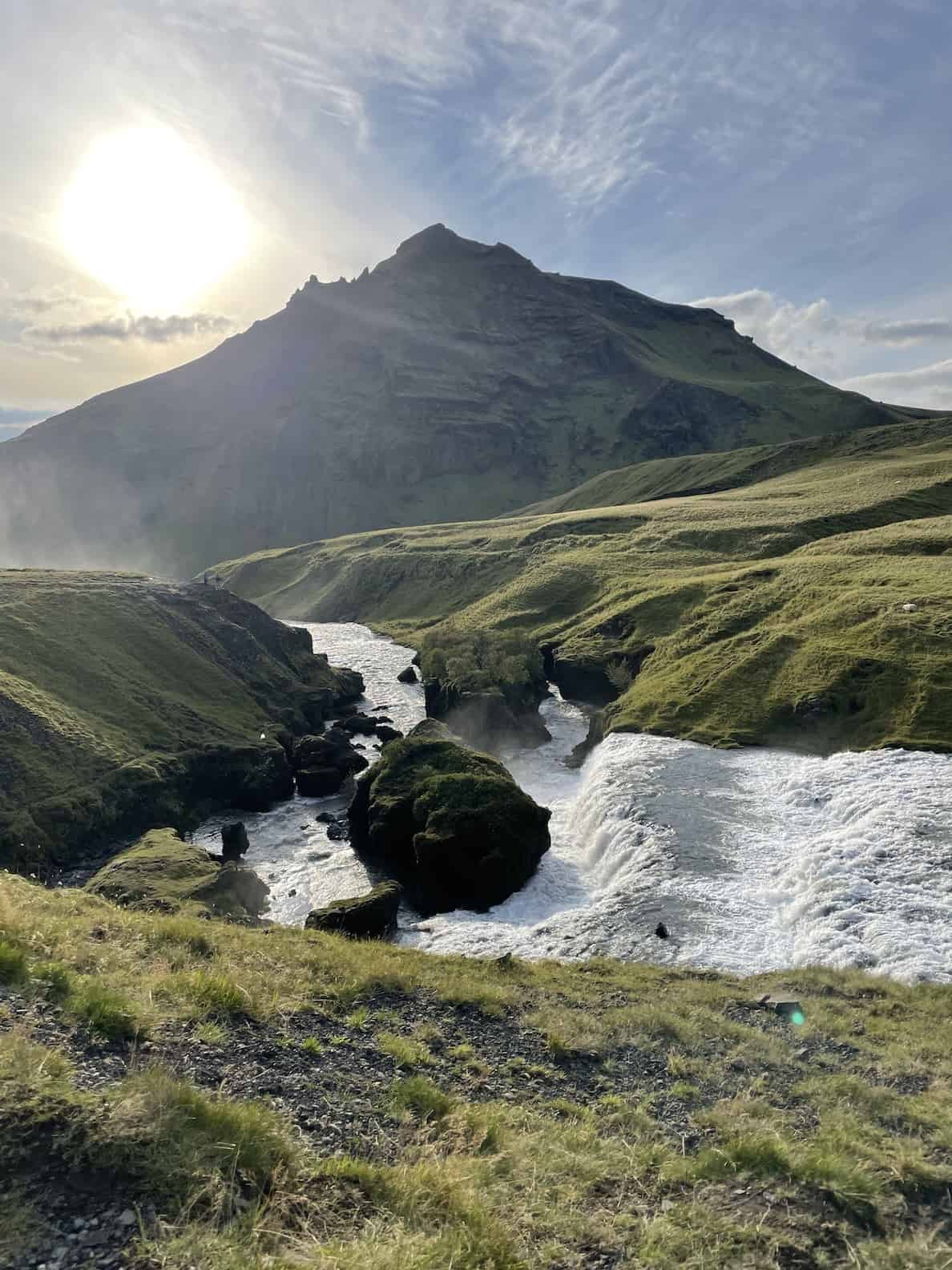 lush-green-mountains-with-strong-river-flowing-through-sheep-in-distance-iceland-road-trip