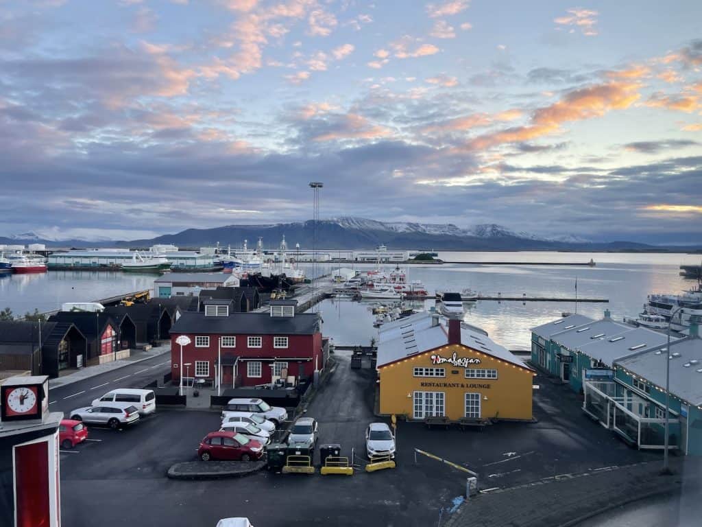 sunrise-over-old-harbor-in-downtown-Reykjavik-with-colorful-buildings-in-forefront-mountains-in-background