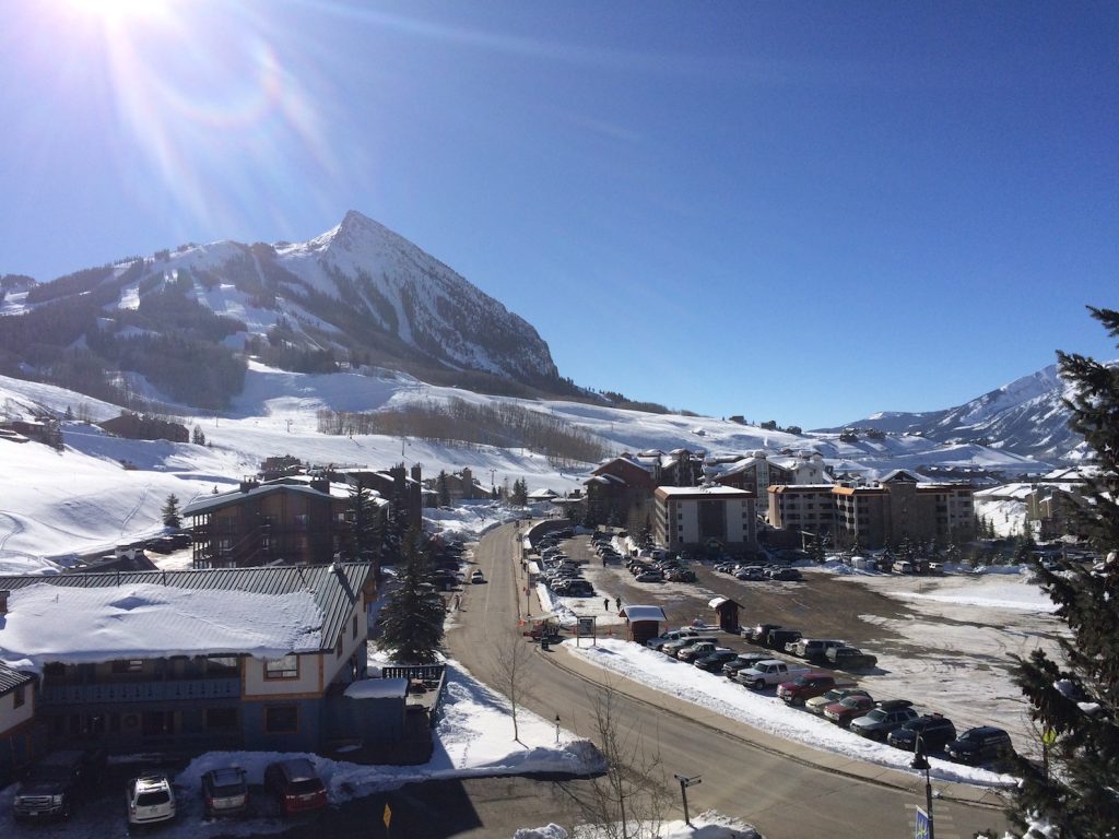 Snow covered mountain overlooking ski town on sunny winter day. Mt. Crested Butte, Crested Butte, Colorado.