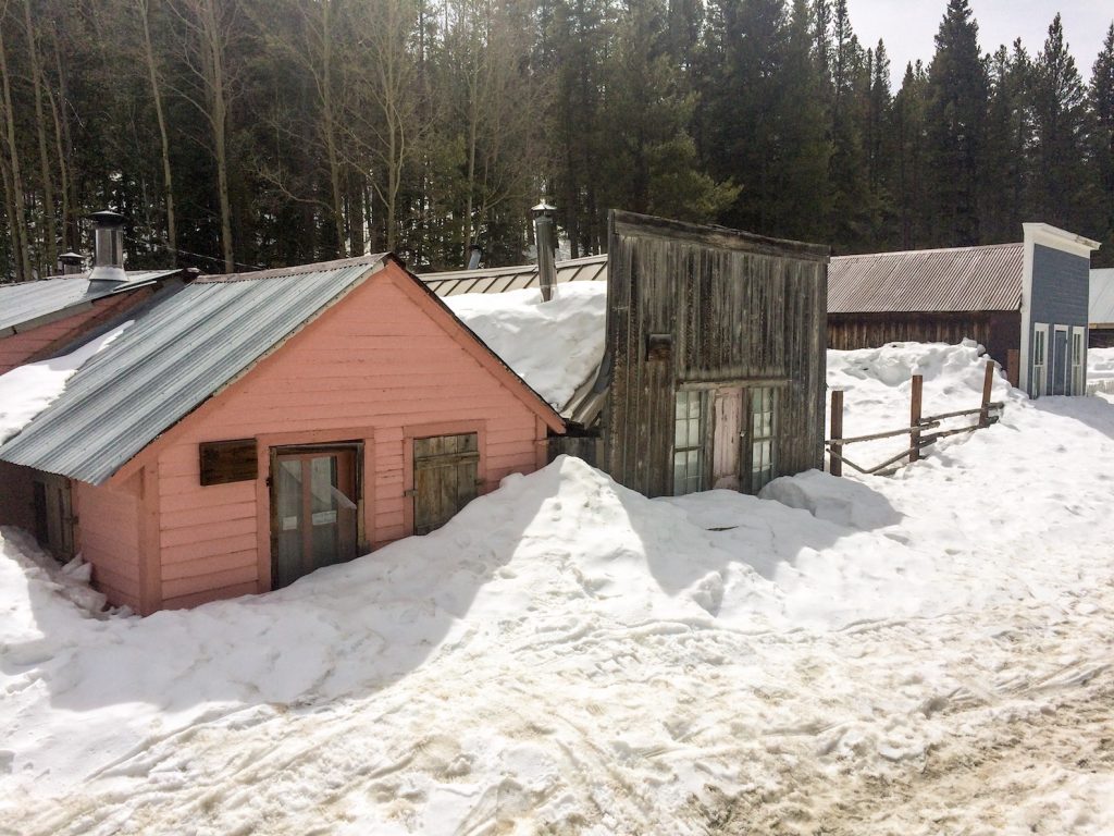 Ghost town with historic buildings covered in deep snow on sunny winter day. St. Elmo Ghost Town, Buena Vista, Colorado.