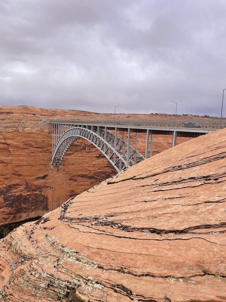Arched bridge across red rock landscape in desert. Glen Canyon Dam Bridge, Glen Canyon Dam, Page, Arizona.