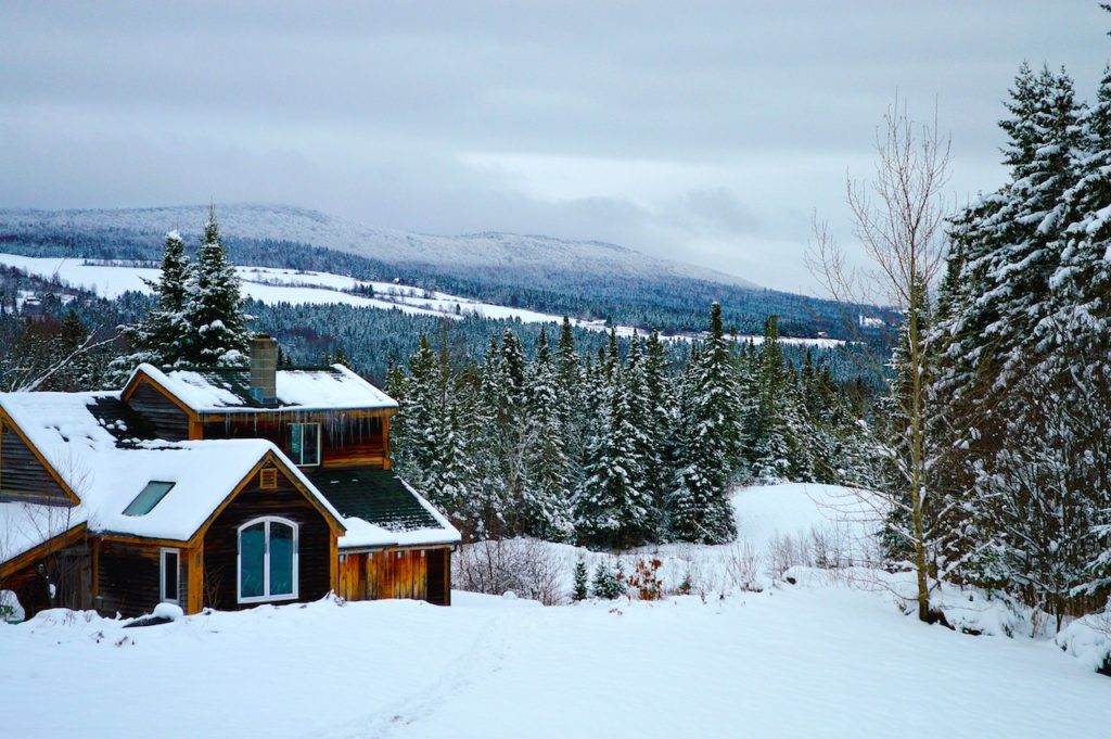 Mountain cabin covered in snow overlooking picturesque mountain view. White Mountains, New Hampshire.
