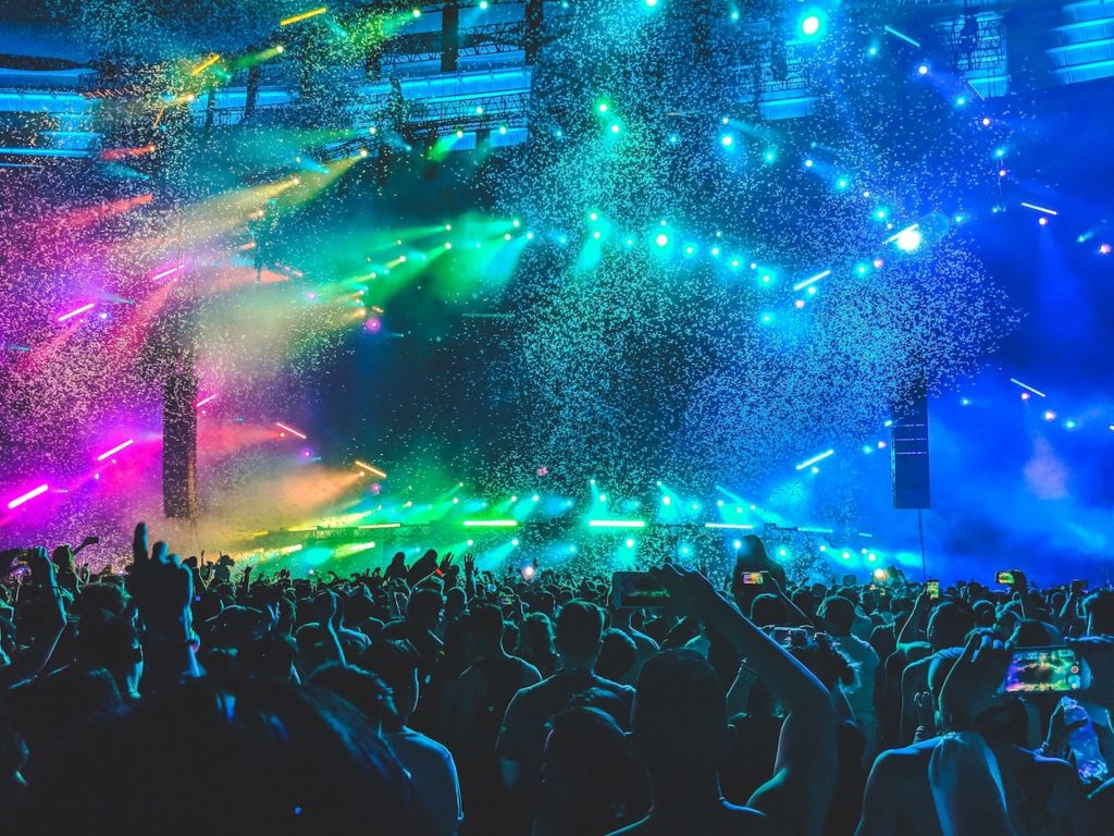 colorful lights and confetti falling down on huge crowd in dimly lit superclub in miami south beach florida