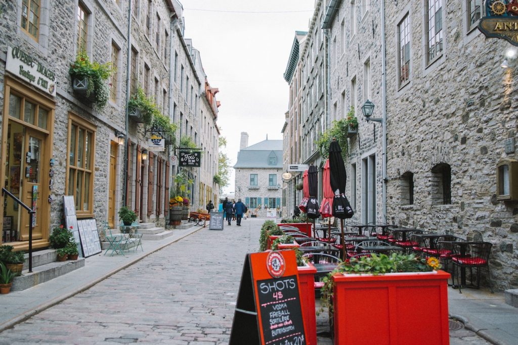 Cobblestone pedestrian alley with sidewalk seating between pretty stone buildings. Old Quebec City, Canada