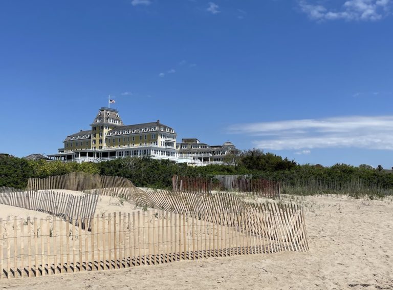 Large yellow and white hotel directly on beach overlooking Atlantic Ocean on sunny summer day. Ocean House Historic Hotel, East Beach, Westerly, Watch Hill, Rhode Island, New England.