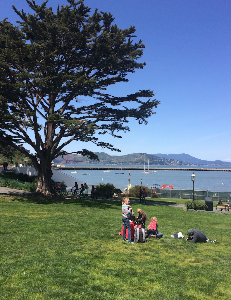 Kids playing on grass park overlooking San Francisco Bay and Golden Gate Bridge. Ghirardelli Square, San Francisco, California. 1 Day in San Francisco itinerary.