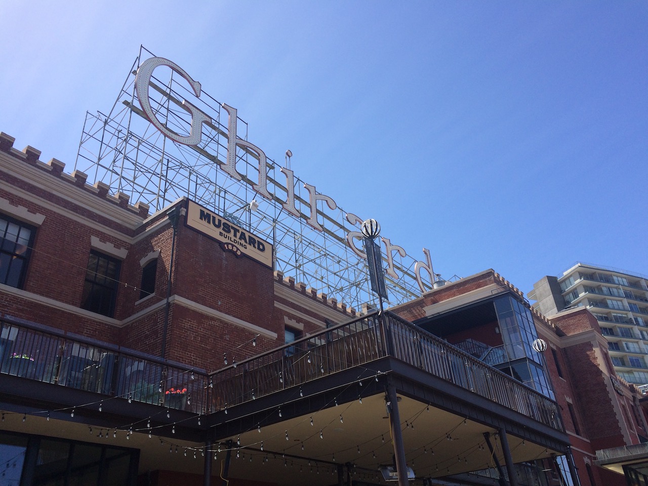 Brick building with large, free-standing sign reading "Ghirardelli." Ghirardelli Square, San Francisco, California. 1 Day in San Francisco itinerary.