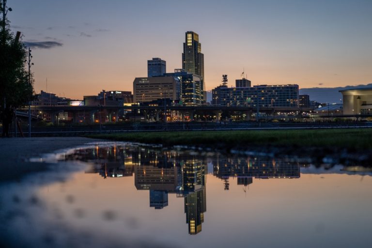 Twilight shot of downtown Omaha skyline reflecting in water. Omaha, Nebraska.
