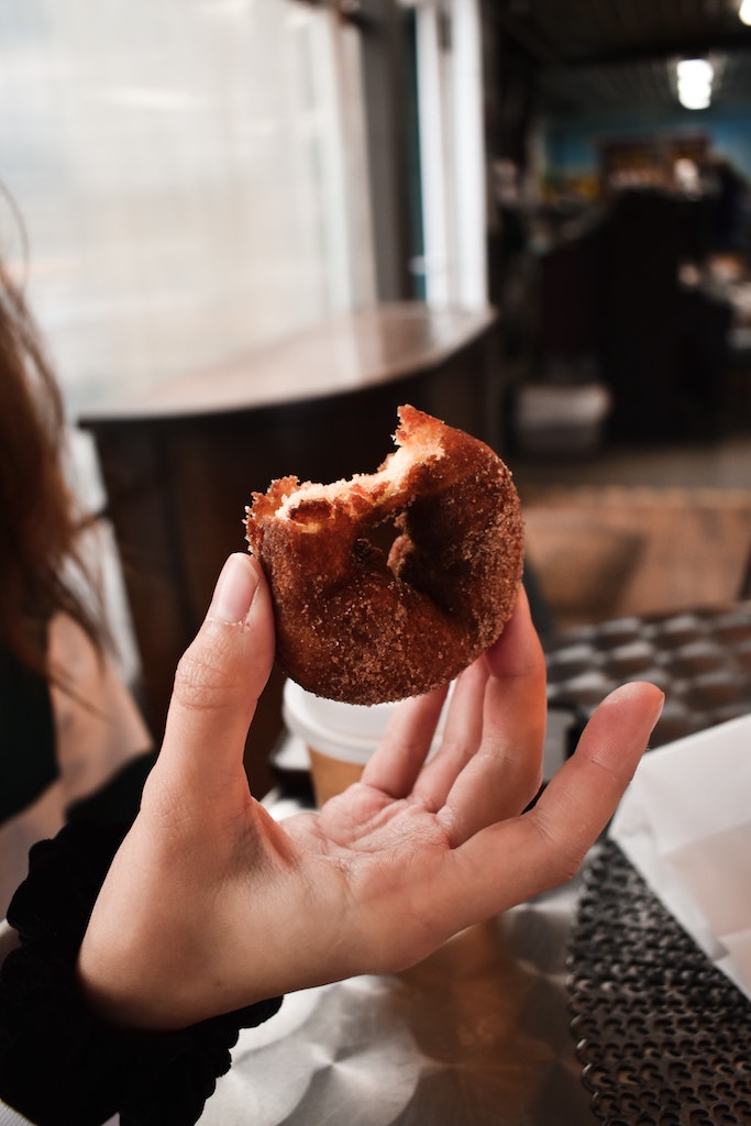 Woman holding cider doughnut. Upstate, New York - Upstate New York in fall