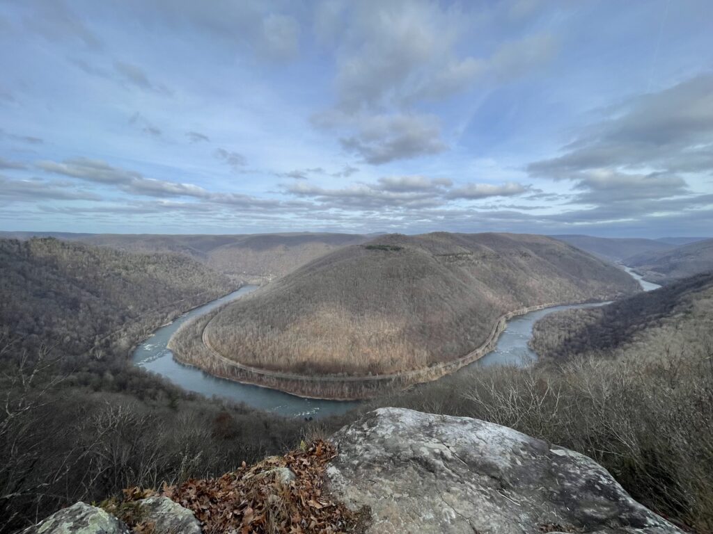 New River winding through small mountains covered in bare trees during winter. Grandview Overlook, New River Gorge National Park, West Virginia.