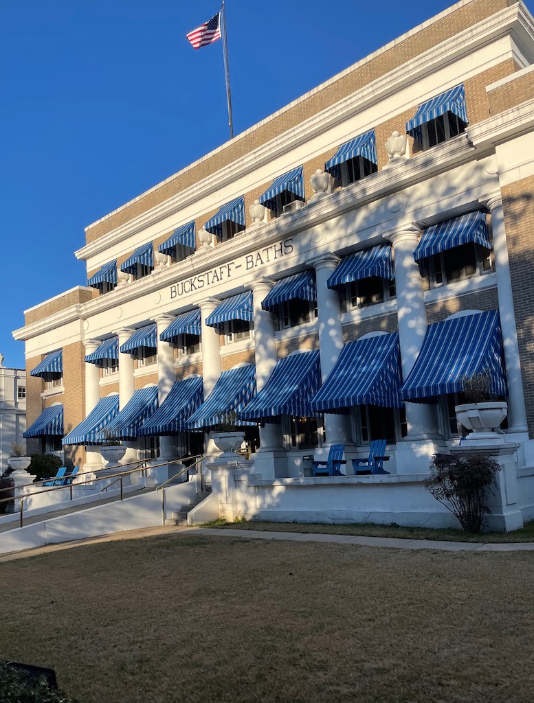 Old, tan three-story building with stately blue striped awnings. Buckstaff Baths, Hot Springs National Park, Hot Springs, Arkansas.