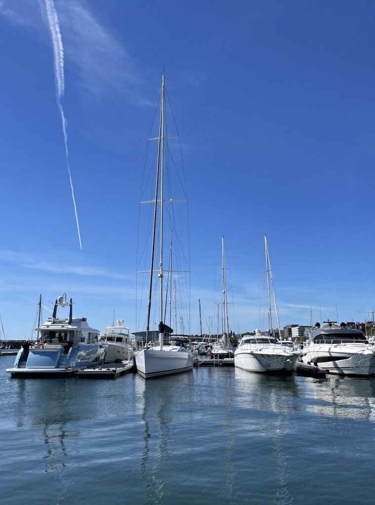Line of sailboats and yachts in quiet harbor on sunny day. Portland, Maine.
