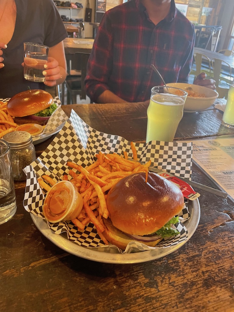 Man and woman with vegan burgers and fries and local craft beer in restaurant. Historic Brewing Barrel and Bottle House, downtown Flagstaff, Arizona.