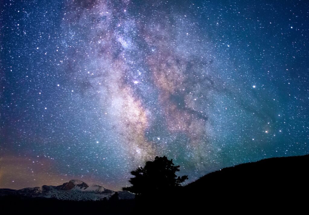 Shot of stars and milky way at night with silhouette of mountains in foreground. Night sky, Estes Park, Colorado.
