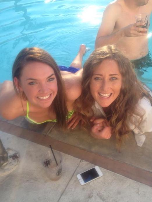 Two young woman in pool smiling and laughing at camera during early evening in fall. Pool at Planet Hollywood Hotel & Casino, Las Vegas, Nevada.