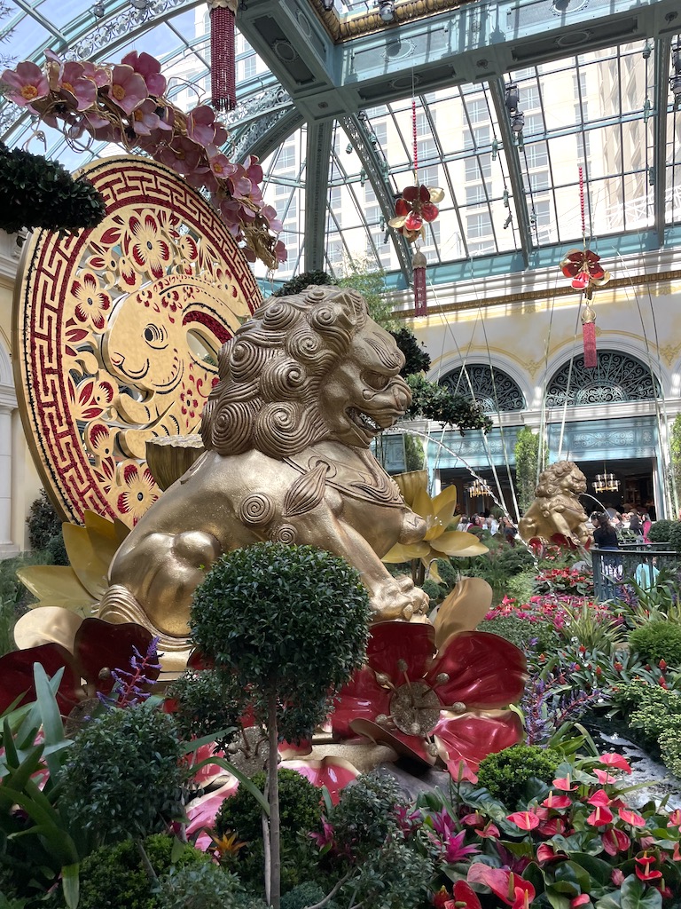 Lion and Rabbit statues surrounded by flowers in conservatory with huge, open skylight ceiling. Bellagio Conservatory and Botanical Gardens, Bellagio Hotel and Casino, Las Vegas, Nevada.