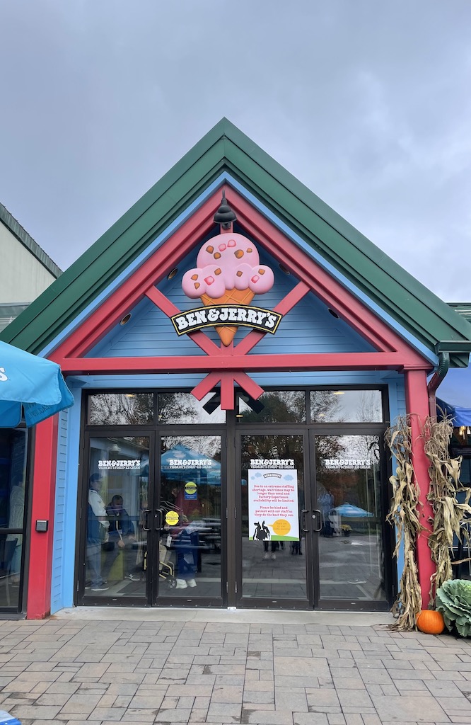 Colorful storefront of Ben & Jerrys, with ice cream sign reading "Ben & Jerry's" on cloudy fall day. Ben & Jerry's Waterbury Factory Tour, Waterbury, near Stowe, Vermont.