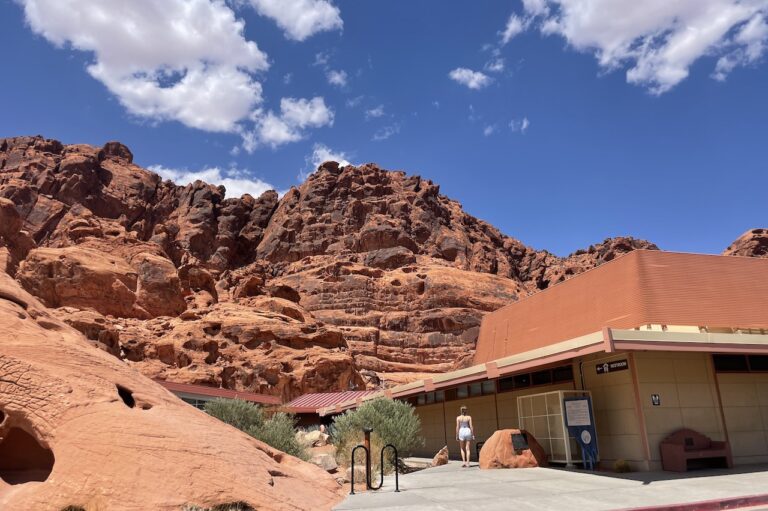Simple visitor center building with dramatic red rock landscape in back on sunny day. Visitor Center, Valley of Fire State Park, near Las Vegas, Nevada.