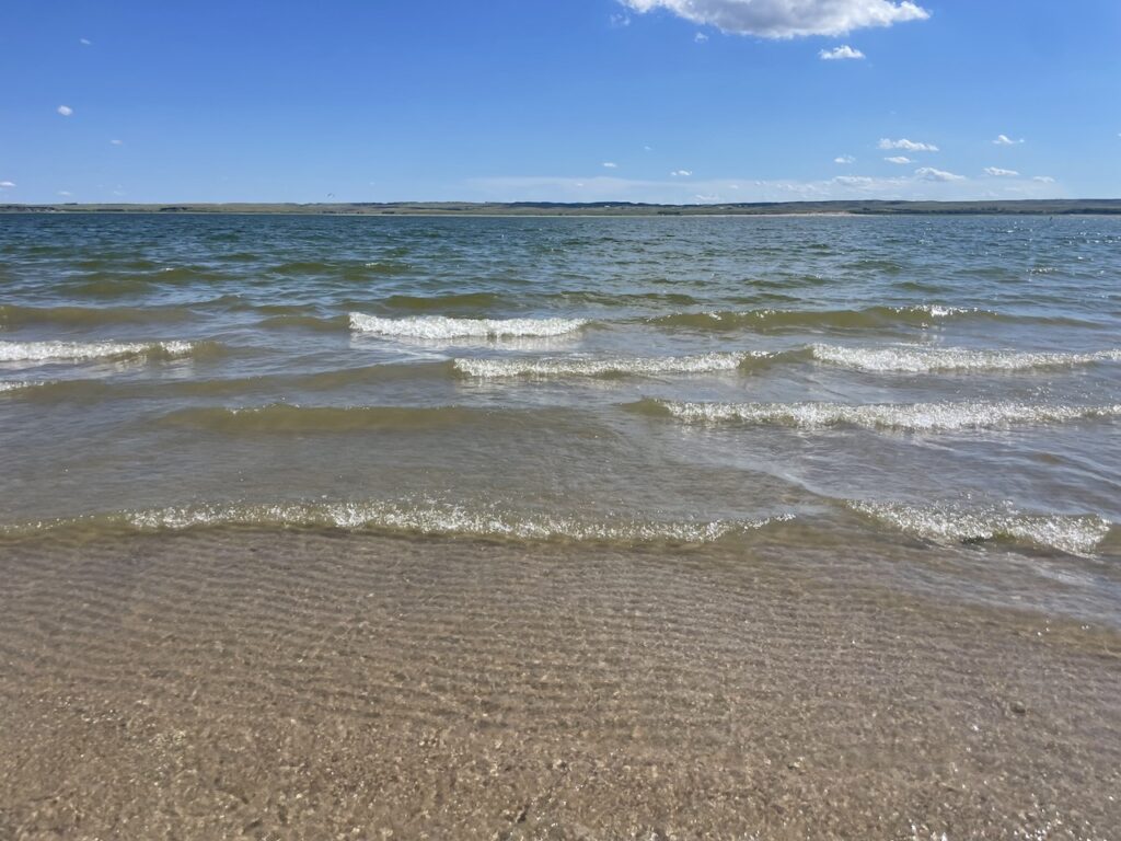 Small waves crashing on shore of sandy beach during sunny summer day. Lake McConaughy, Nebraska.