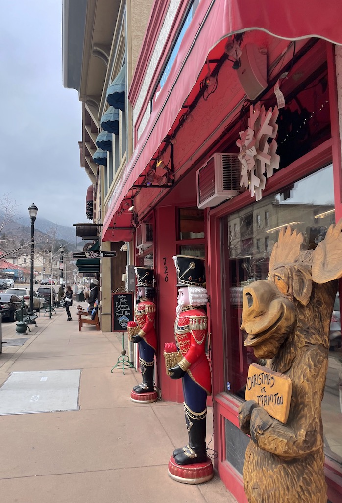 Shops lining main street, with colorful building facades and decorations on gloomy winter day. Shopping in downtown Manitou Springs, Colorado Springs, Colorado.