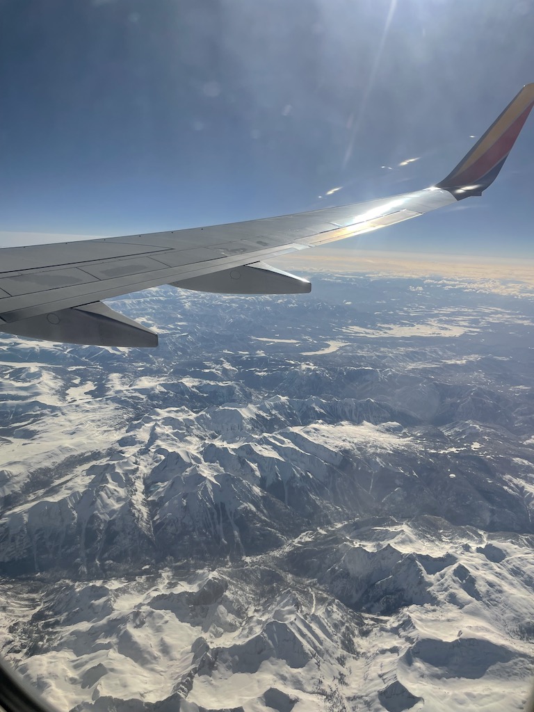 plane above rocky mountains colorado holiday travel