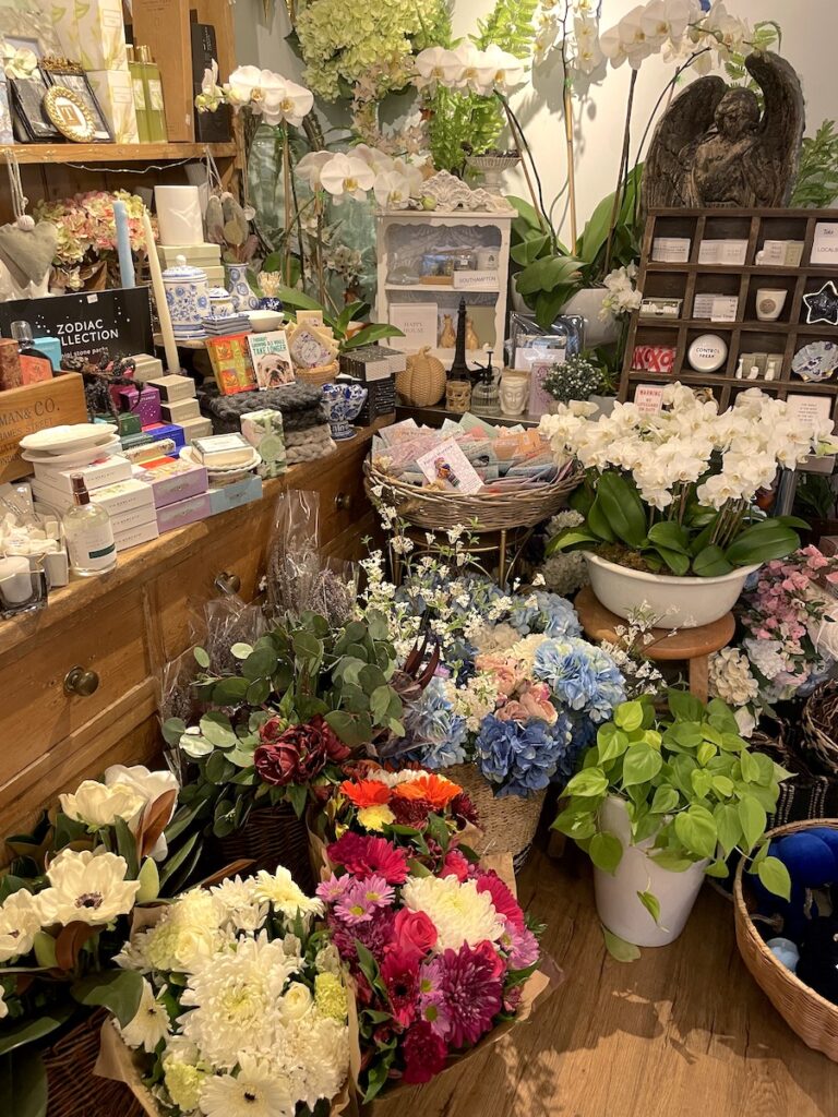 Interior of shop full of flowers, cards, and small gifts. Topiaire Flower Shop, Village of Southampton, Main Street shopping, Southampton, New York, The Hamptons.