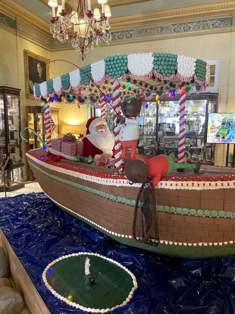Huge gingerbread house in shape of boat with Santa driving the boat, gingerbread is in historic hotel. Broadmoor Gingerbread Display, The Broadmoor Hotel, Colorado Springs, Colorado.