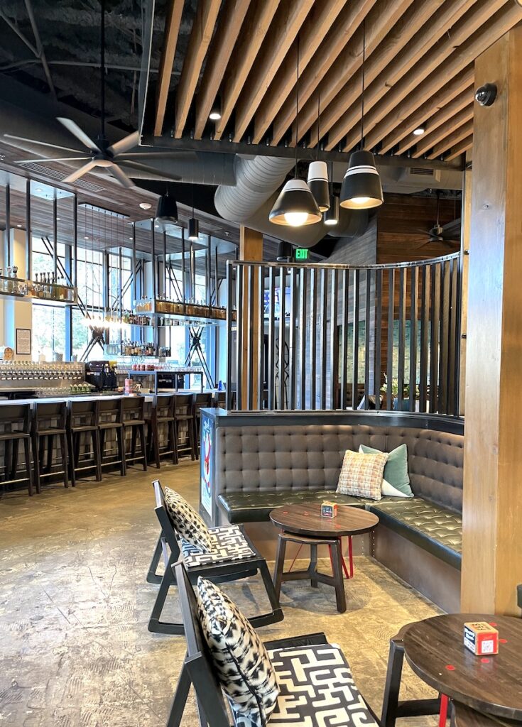Contemporary, industrial indoor space with comfortable seating and large bar top and coffee bar in background. Avanti Food & Beverage, Boulder, Colorado.