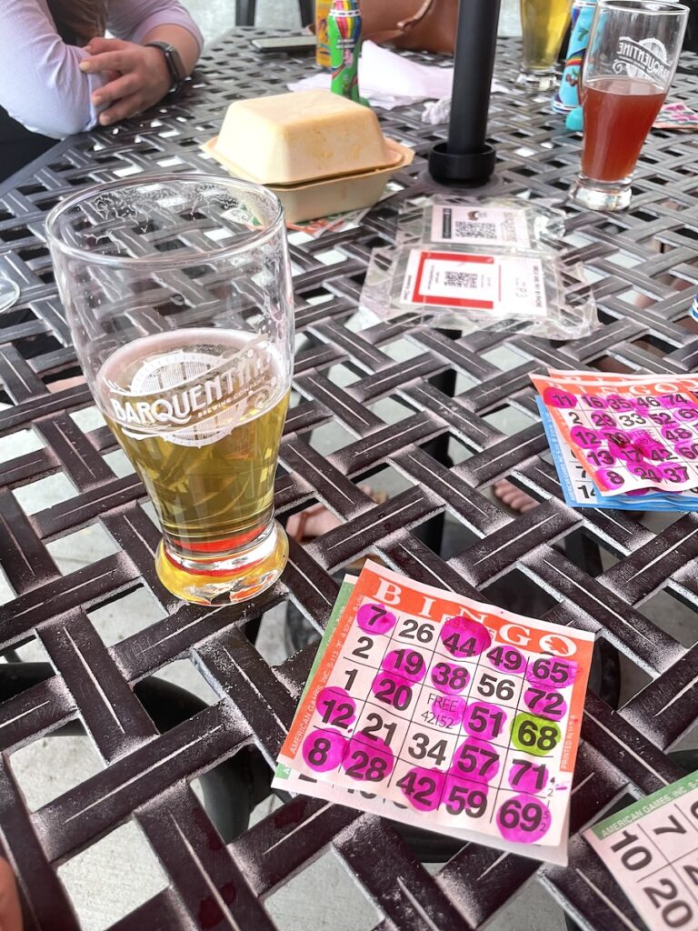 Patio table with craft beers and colorful bingo cards. Barquentine Brewing Co., Edgewater Public Market, Edgewater near Denver, Colorado.