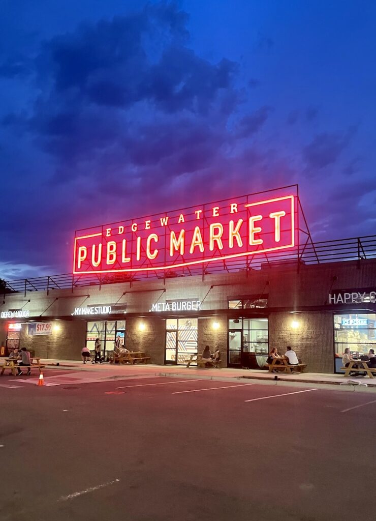 Building with large red, neon lit sign at night reading "Edgewater Public Market". Edgewater Public Market, Edgewater near Denver, Colorado.
