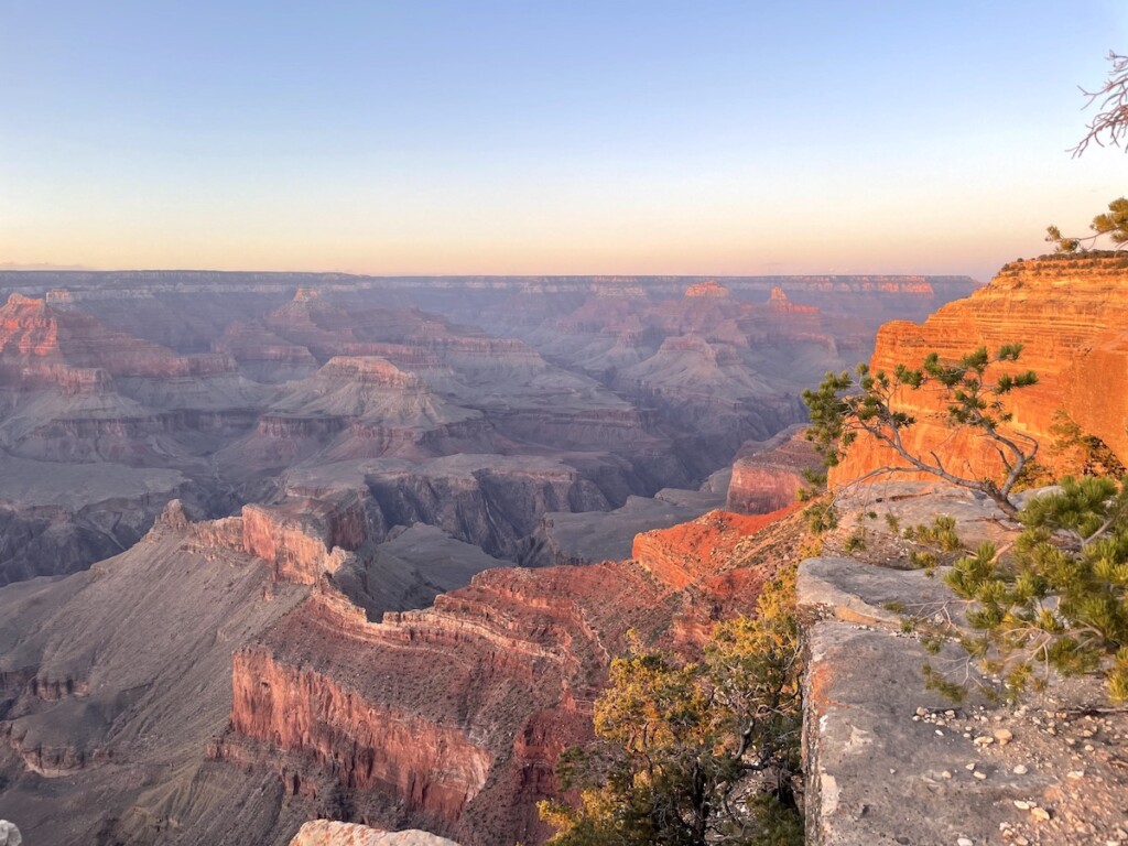 Sunset over Grand Canyon, rocks are bright red, orange, and purple on cloudless spring evening. Mohave Point, Grand Canyon National Park South Rim, Arizona.