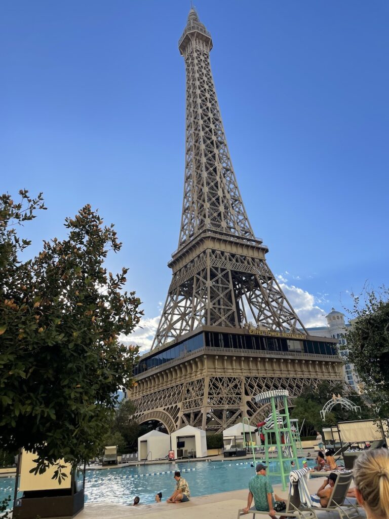 Outdoor pool under massive Eiffel Tower replica on sunny day. Paris Hotel & Resort pool, Las Vegas, Nevada.