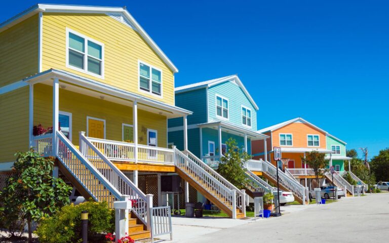 Yellow, blue, orange pastel houses on in beach town on cloud-less sunny day. Key West, Florida.