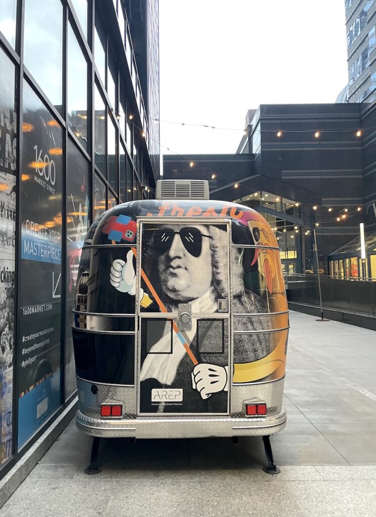 Small van covered in printed graphic with trendy print of Benjamin Franklin. Philadelphia, Pennsylvania.