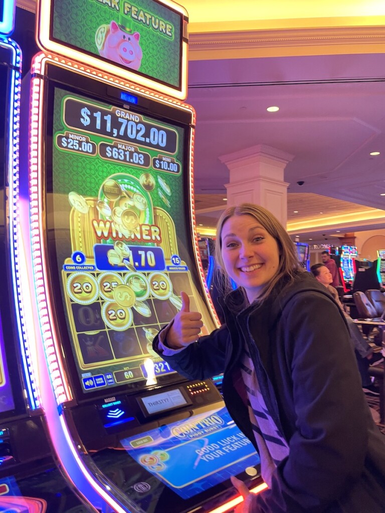 Woman smiling next to slot machine which just won bonus in casino. Horseshoe Casino, Council Bluffs, Iowa, near Omaha, Nebraska.