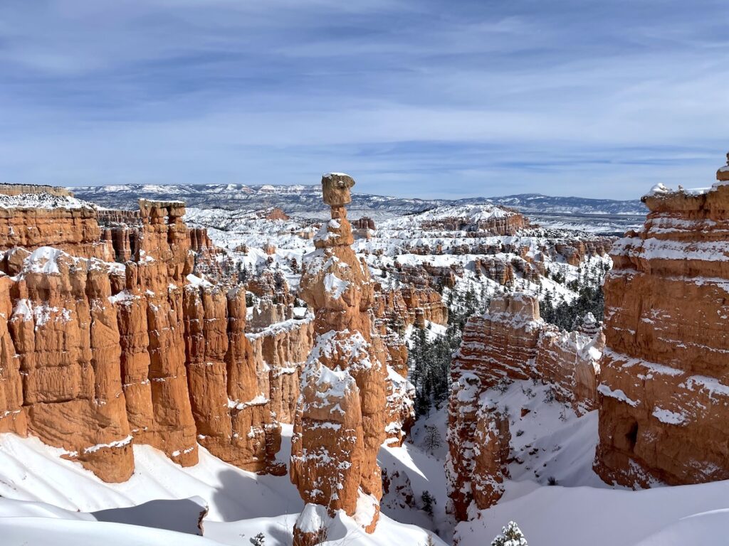 Large red/orange hoodoos covered in snow on sunny winter day. Thor's Hammer, Bryce Canyon National Park, Utah.