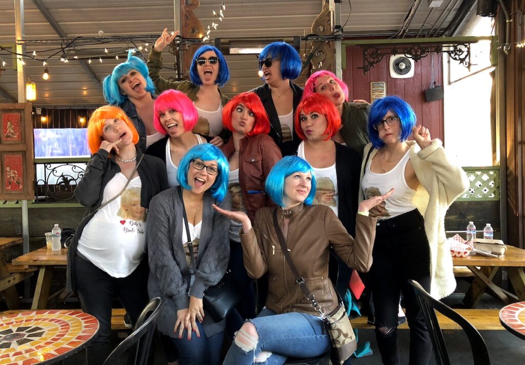 Group of women in short colorful wigs celebrating a bachelorette party. San Francisco, California.