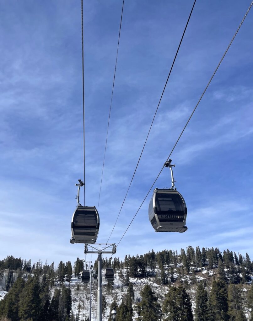 Ski gondolas heading up a mountain on sunny winter day. Breckenridge Ski Resort, Peak 8 Gondola, Breckenridge, Colorado.