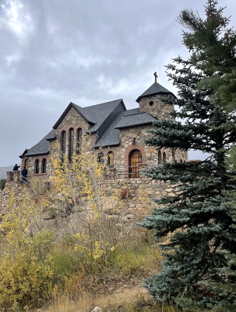 Stone church in mountains surrounded by fall colors and pine trees on gloomy fall day. Chapel On The Rock, Allenspark, near Estes Park, Colorado.