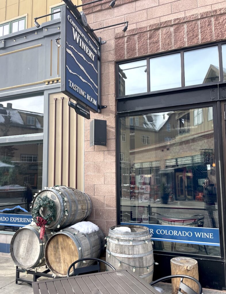 Storefront of winery with tables and wooden barrels of wine out front. Continental Divide Winery, Breckenridge Village Resort, Breckenridge, Colorado.