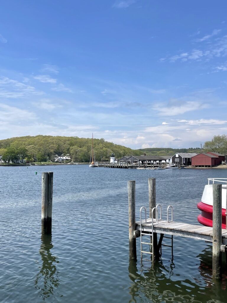Boat and docks on calm water on sunny summer day. Mystic Seaport, Mystic, Connecticut.