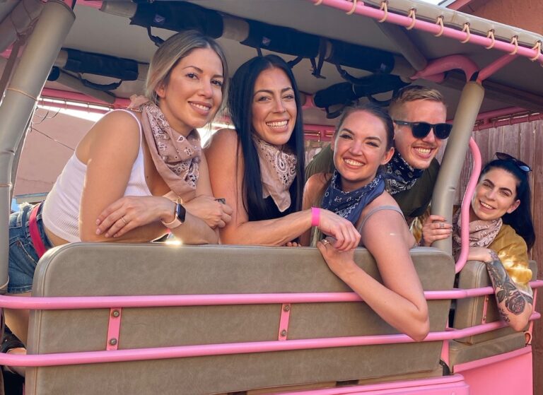Group of friends smiling in pink jeep with open air windows during girls trip. Pink Jeep Tours, Broken Arrow Route at sunset, Sedona, Arizona.