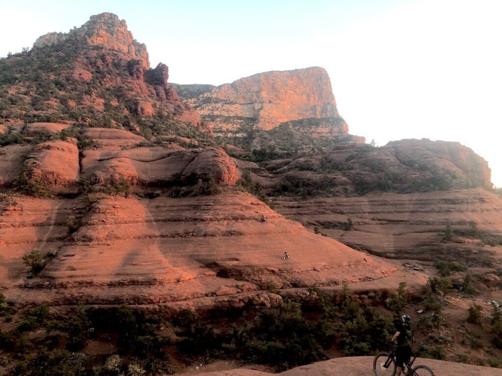 Mountain biker looking at slick red rock mountain during sunset. Sedona, Arizona.