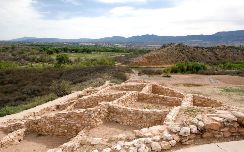 Hilltop pueblo ruins overlooking green valley surrounded by mountains. Tuzigoot National Monument, Cottonwood, Arizona (near Sedona).