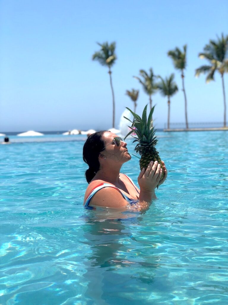woman in the pool with pineapple drink dreams los cabos all inclusive resort cabo san lucas mexico