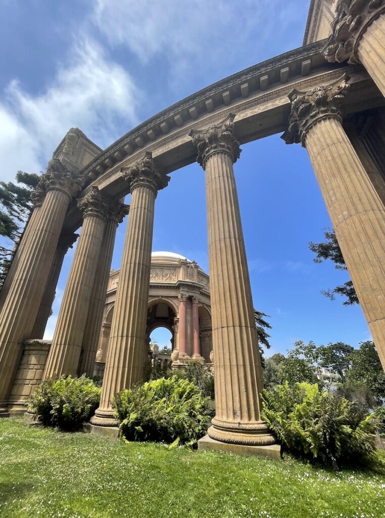 Large columns and rotunda on grassy lawn on sunny day. Palace of the Fine Arts, San Francisco, California.