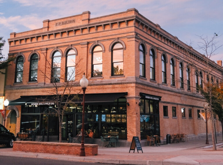 Exterior of historic brick building in downtown district during sunset. The Rathbone Hotel, Montrose, Colorado.