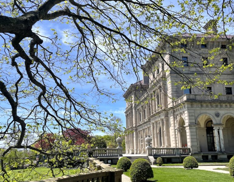 Green and lush gardens surrounding Gilded-age mansion on sunny spring day. The Breakers Mansion, Newport, Rhode Island.