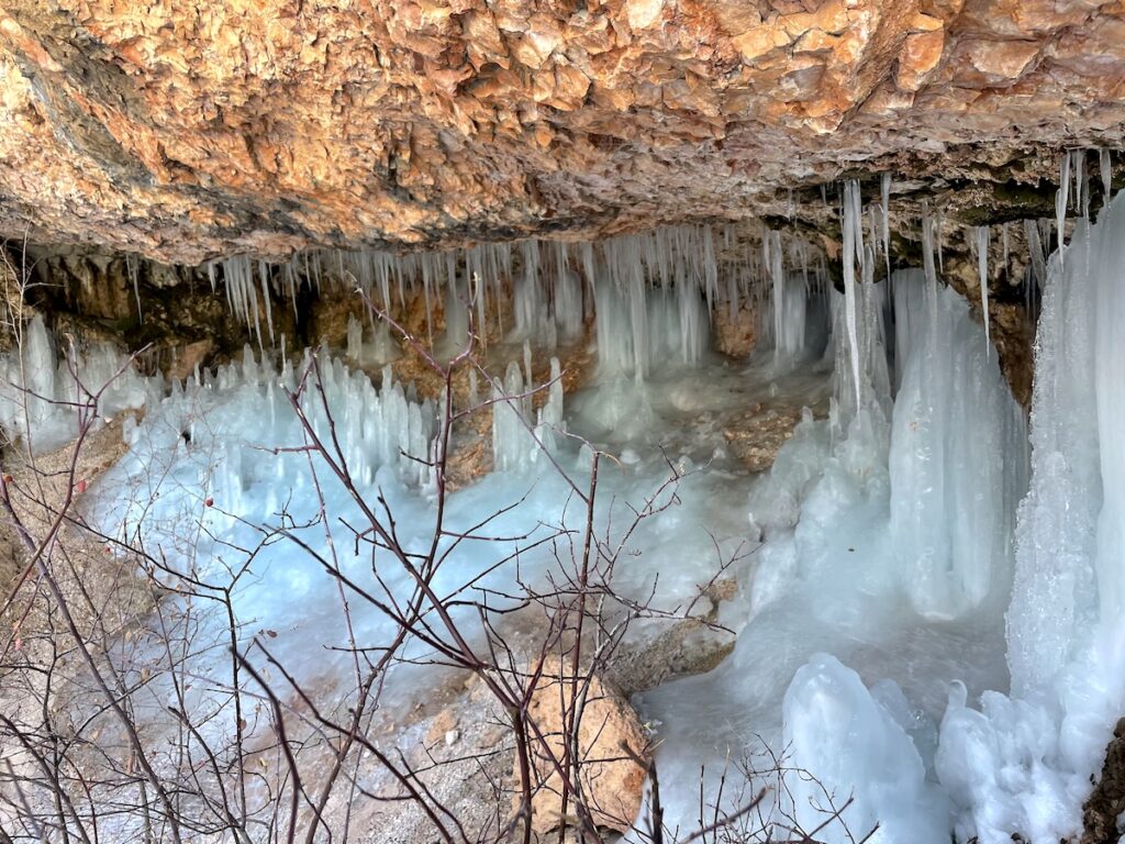 Red rock cave covered in icicles. Hiking Mossy Cave in Bryce Canyon National Park, Utah.